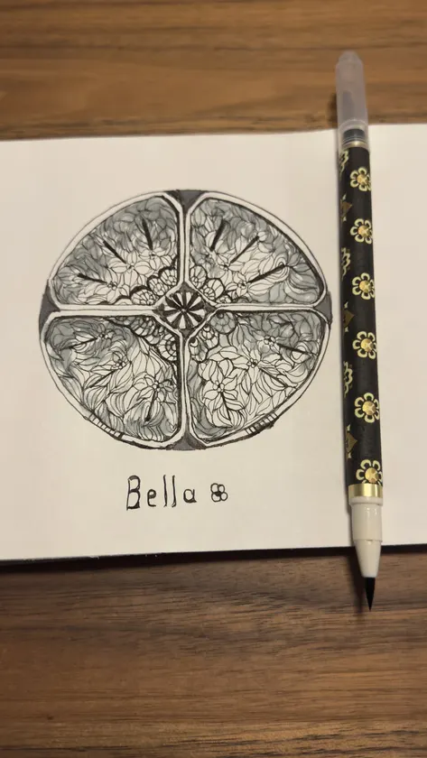 An intricate circular structure takes shape through a detailed sketchbook drawing.