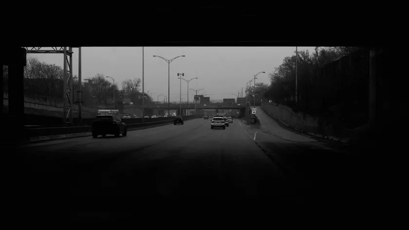 حركة المرور تتبع أفقًا منخفضًا تحت سماء رمادية عريضة.
